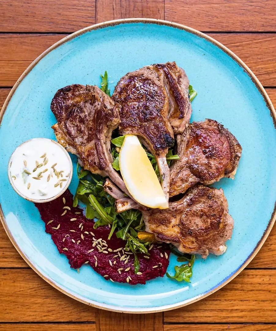 Lamb cutlets served on a blue plate
