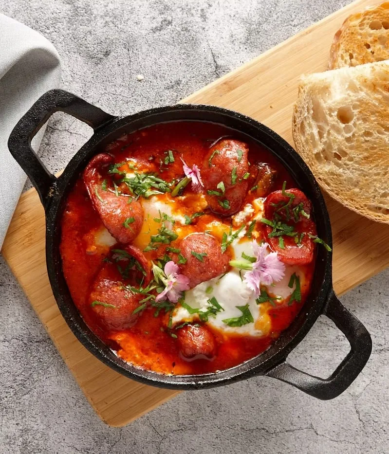 Shakshuka with chorizo in a cast-iron pan, served with sourdough